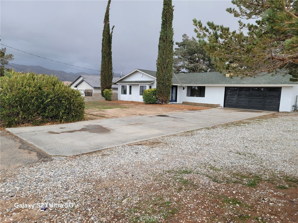 18425 Ranchero Road Hesperia, CA 92345 - Photo 1 of 1 a view of a house with a yard and garage