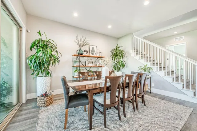 a dining room with wooden floor a chandelier a wooden table and chairs