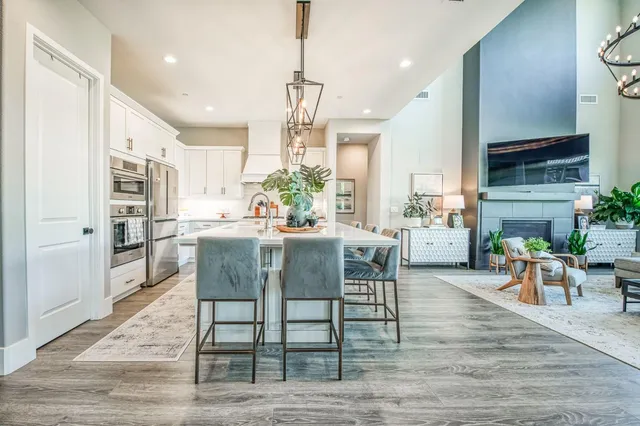 a kitchen with stainless steel appliances granite countertop a table chairs stove a refrigerator and cabinets