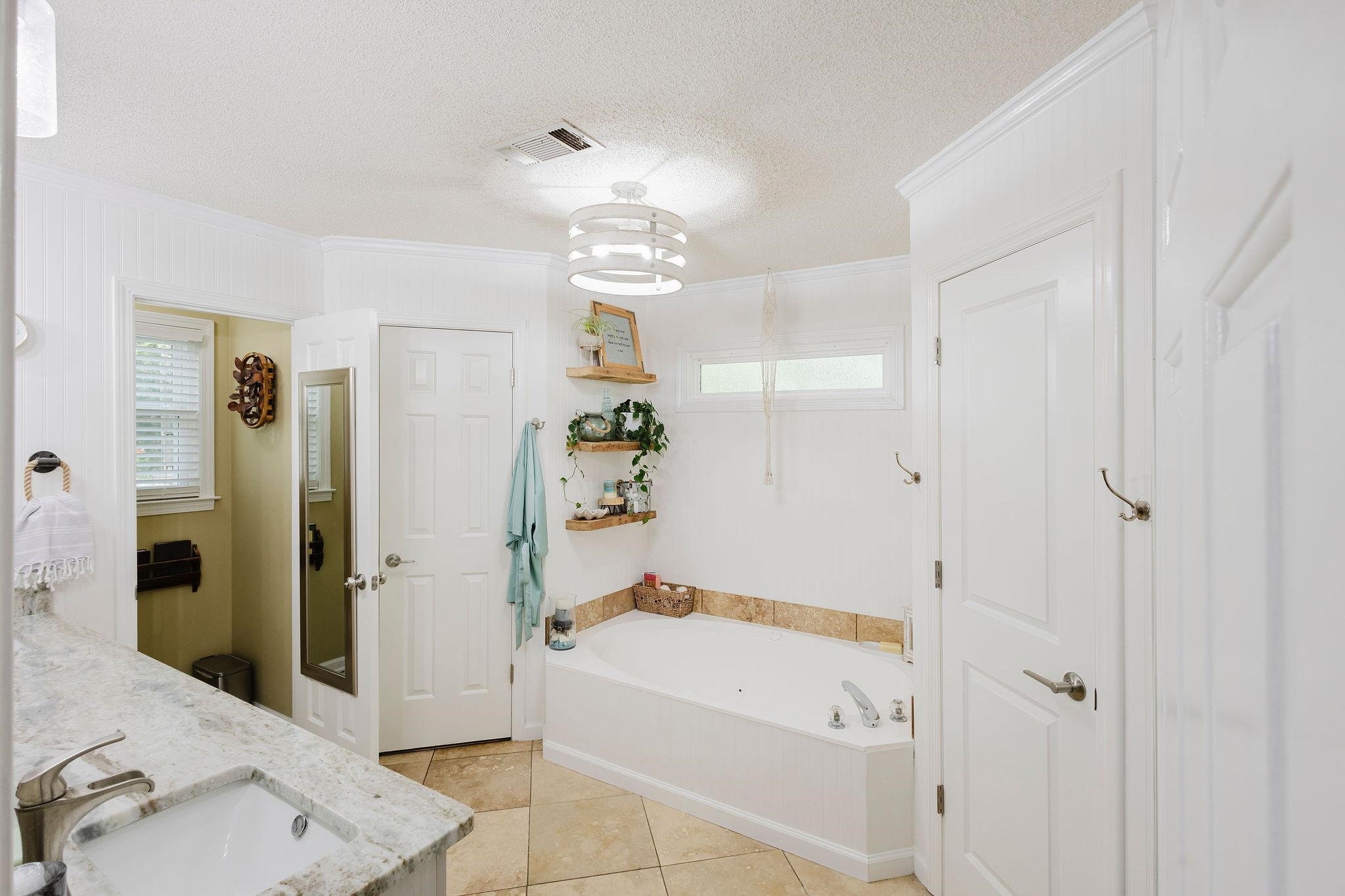305 Great Falls Road Collierville, TN 38017 - Photo 10 of 23 Bathroom featuring a built-in tub, a vanity with an undermount sink and stone countertop, tile flooring, and white paneling