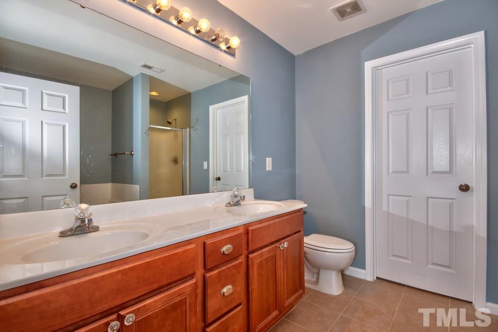 9904 Grettle Court Raleigh, NC 27617 - Photo 13 of 22 Large full bathrooms for both bedrooms. This bath features a garden tub with separate shower, dual sinks and a large walk in closet.