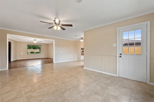 a view of an empty room with window and cabinet