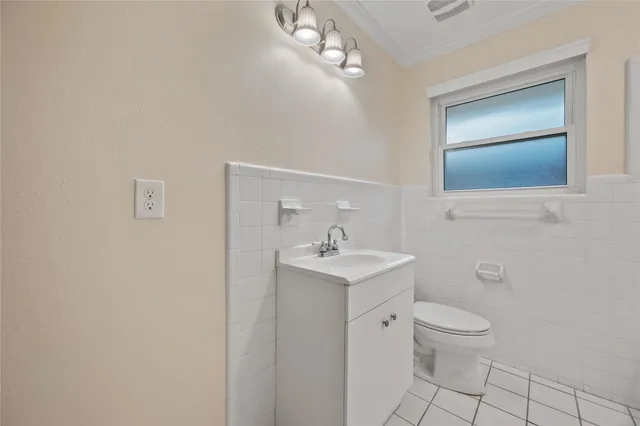 a bathroom with a toilet a sink a mirror and vanity