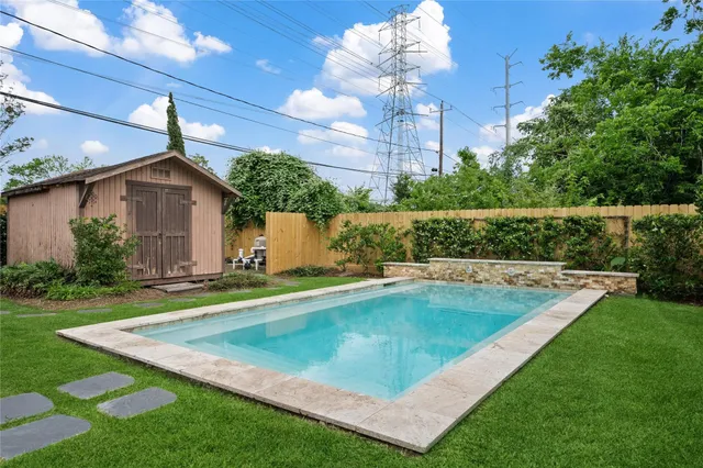 a view of a house with a backyard and swimming pool