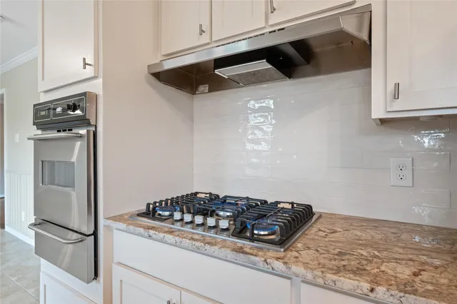 a kitchen with granite countertop a stove and a refrigerator