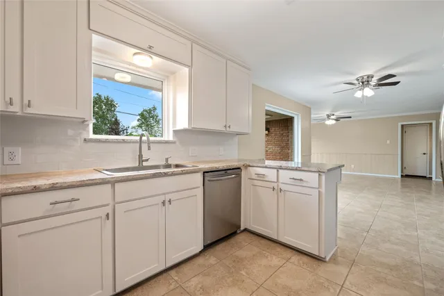 a kitchen with white cabinets and sink