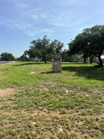 a view of a field with an trees in the background