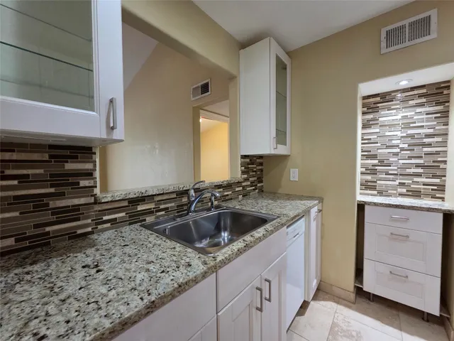 a kitchen with sink stove and cabinets