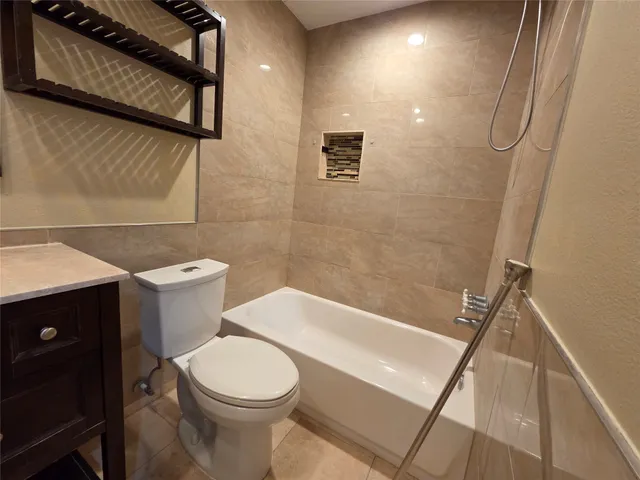a white toilet sitting next to a bathroom sink and vanity