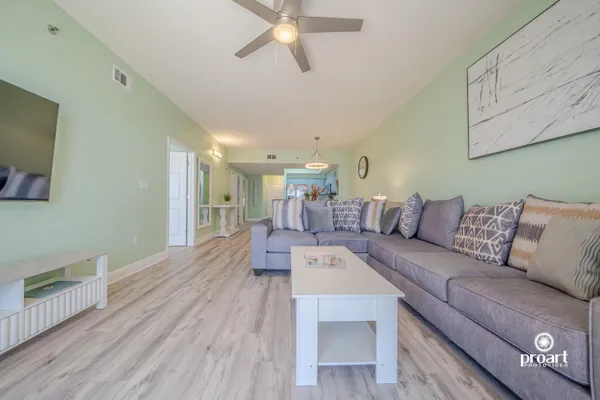 a living room with furniture and a wooden floor