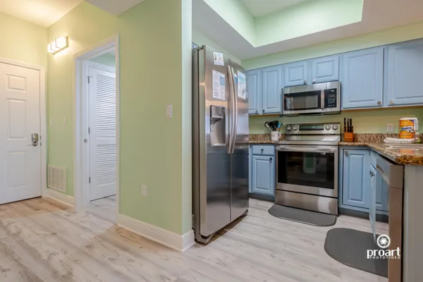 a kitchen with stainless steel appliances granite countertop a stove a refrigerator and a sink
