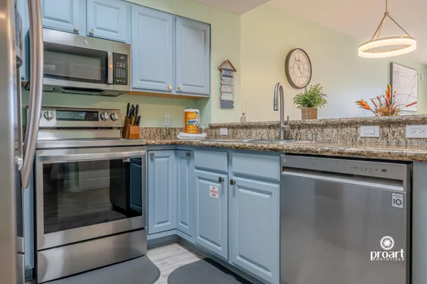 a kitchen with stainless steel appliances granite countertop a sink and a stove