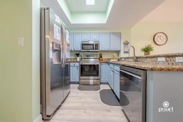 a kitchen with stainless steel appliances granite countertop a stove a refrigerator and a sink