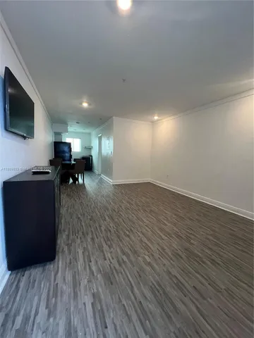 an empty room with wooden floor and furniture