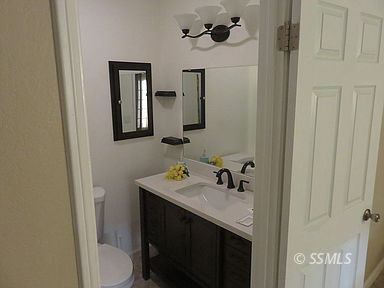 219 Larkspur Street Ridgecrest, CA 93555 - Photo 26 of 34 a bathroom with a sink a toilet and mirror