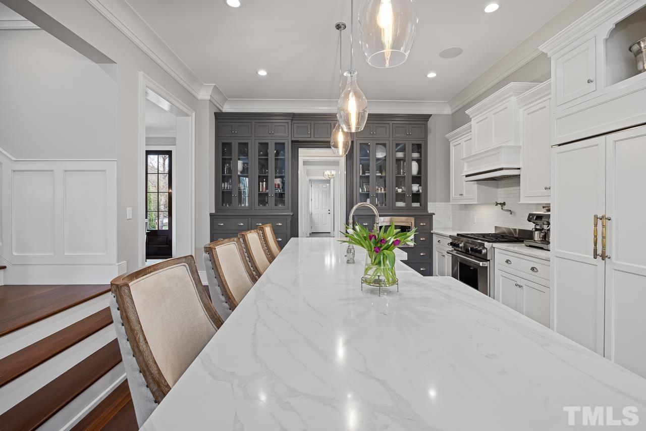 2908 Allansford Lane Raleigh, NC 27613 - Photo 11 of 64 a kitchen with stainless steel appliances kitchen island granite countertop a refrigerator a stove a sink dishwasher and white cabinets with wooden floor