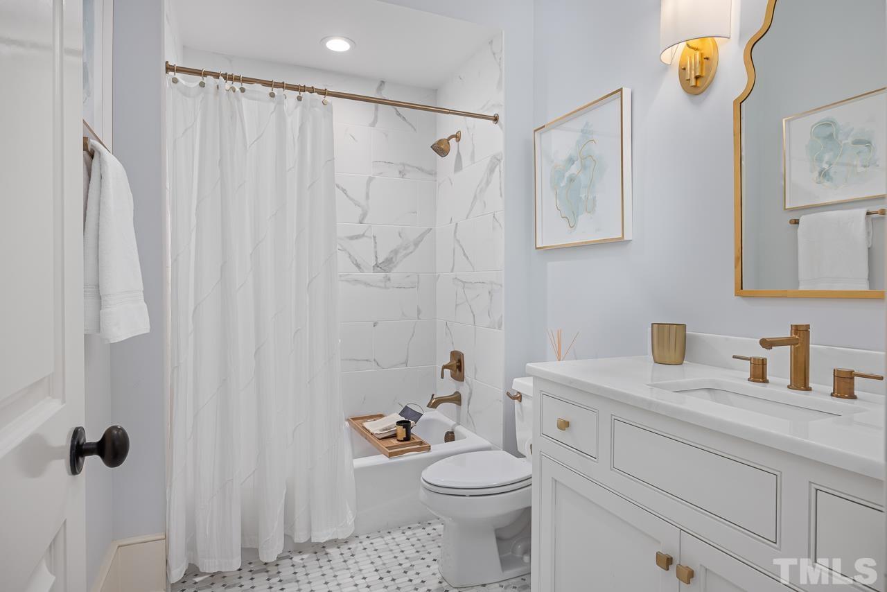 2908 Allansford Lane Raleigh, NC 27613 - Photo 26 of 64 a bathroom with a sink a toilet and shower curtain