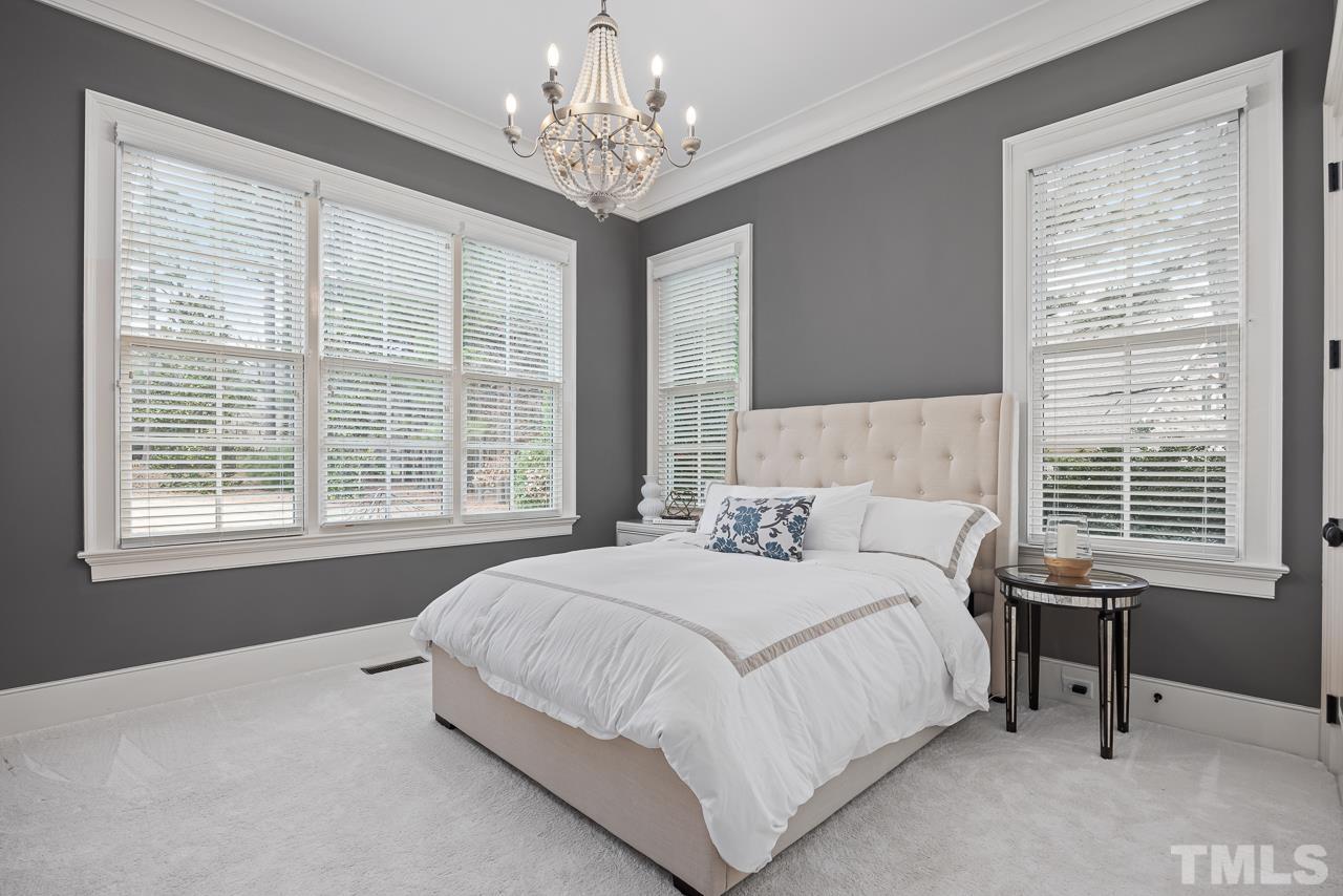 2908 Allansford Lane Raleigh, NC 27613 - Photo 27 of 64 a spacious bedroom with a bed and a table chair