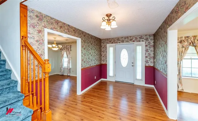 a view of a hallway with wooden floor and staircase