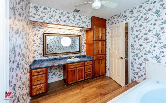 a kitchen with stainless steel appliances granite countertop a refrigerator and a wooden floor