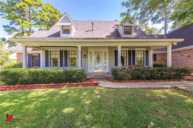 a front view of a house with a big yard and potted plants