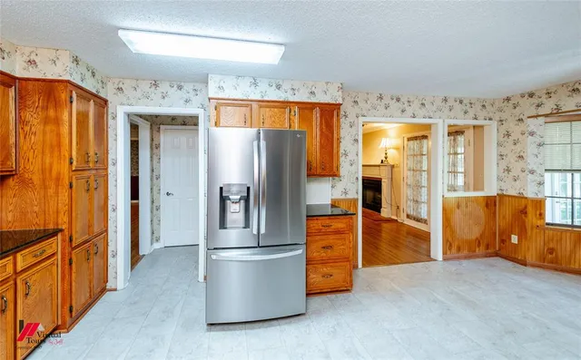 a kitchen with stainless steel appliances a refrigerator and wooden cabinets