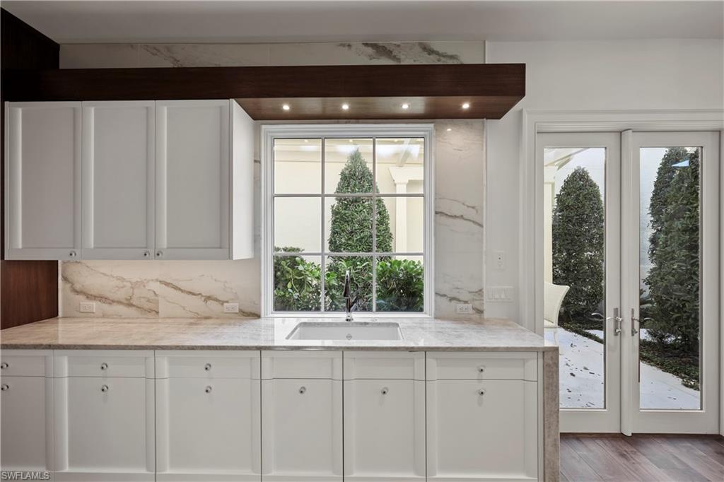 8057 Via Vecchia Naples, FL 34108 - Photo 11 of 42 a kitchen with granite countertop a sink and a window