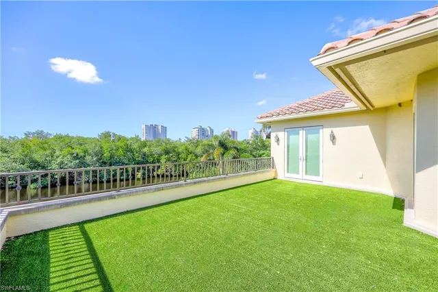 a view of a pool with a bench and yard of the house