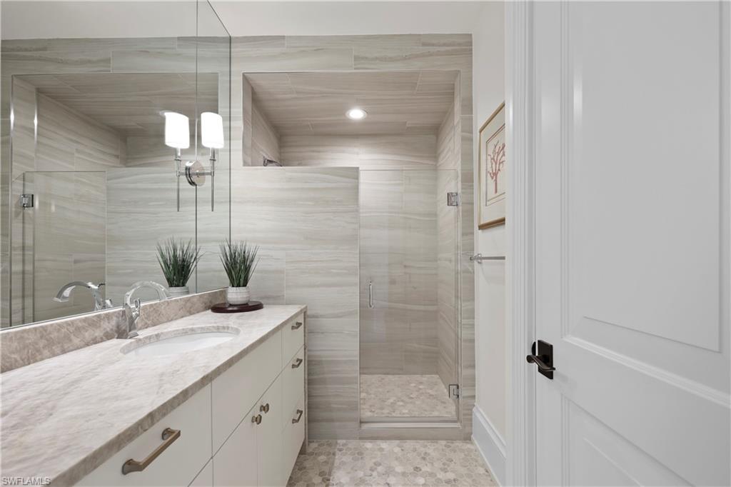 8057 Via Vecchia Naples, FL 34108 - Photo 29 of 42 a bathroom with a granite countertop sink mirror and shower