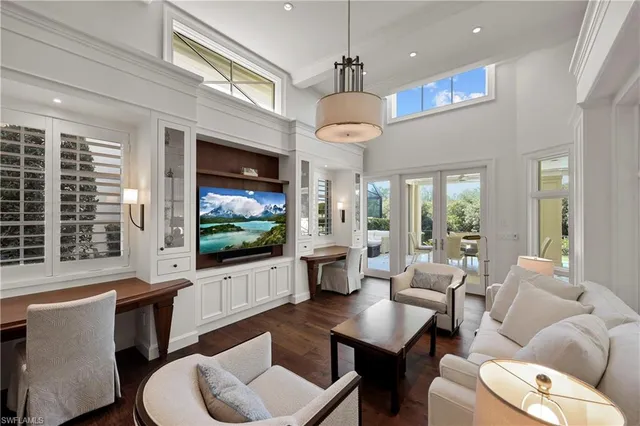 a living room with furniture a flat screen tv and a large window