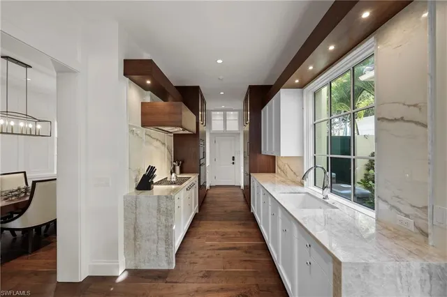 a large open kitchen with stainless steel appliances granite countertop a lot of counter space and a wooden floors