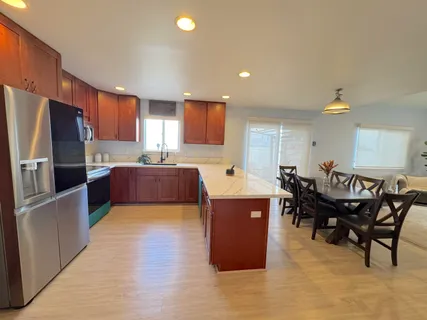 a kitchen with stainless steel appliances wooden cabinets a dining table and chairs