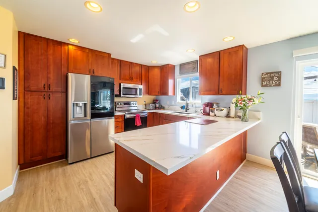 a kitchen with stainless steel appliances a sink a counter top space cabinets and a large window