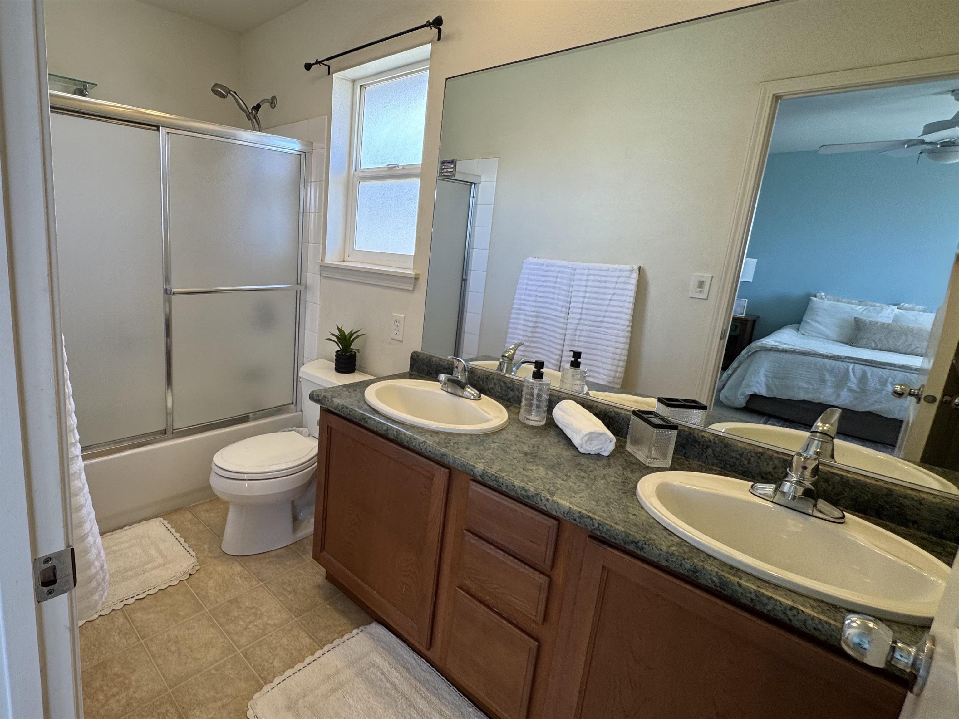 159 Iniiniki Street Wailuku, HI 96793 - Photo 19 of 33 a bathroom with a granite countertop sink toilet a mirror and shower