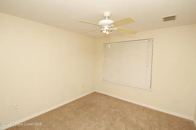 an empty room with a ceiling fan