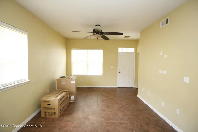 a living room with a table and windows