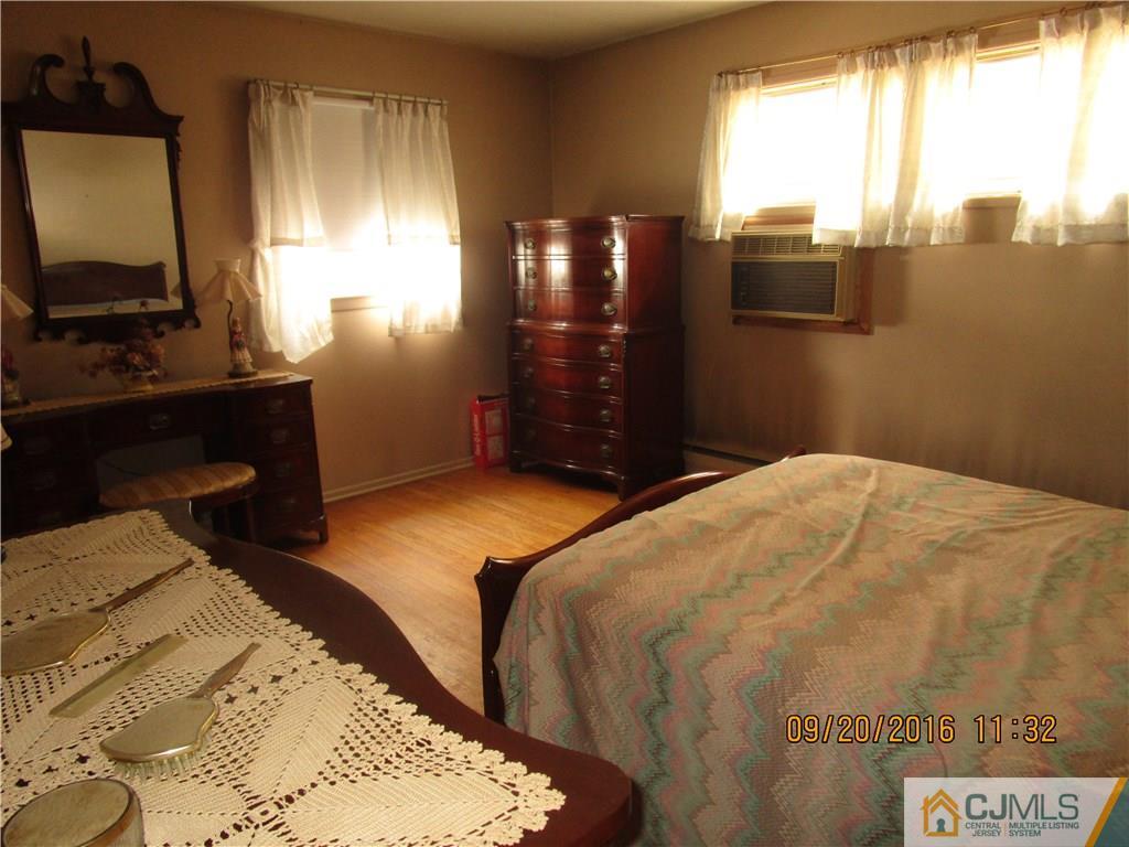 9 Baldwin Road Edison, NJ 08817 - Photo 5 of 8 a bedroom with a bed and a flat tv screen on dresser