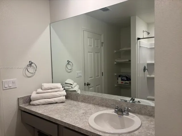 a bathroom with a granite countertop sink and a mirror