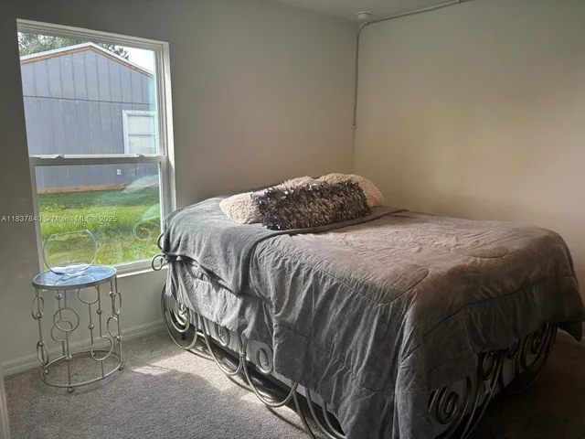 a bedroom with a bed a mirror and a window