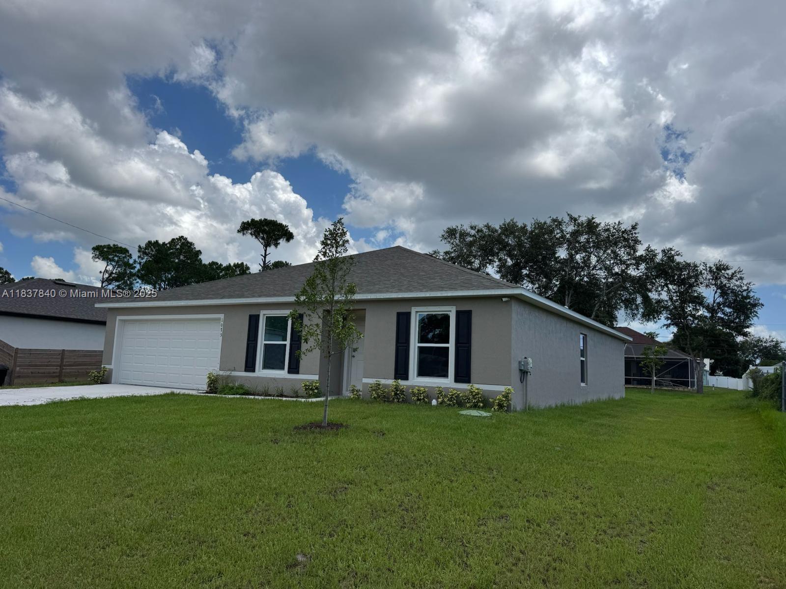 1073 Southwest Eureka Avenue, Unit 1073 Port St. Lucie, FL 34953 - Photo 2 of 25 a front view of house with yard and green space