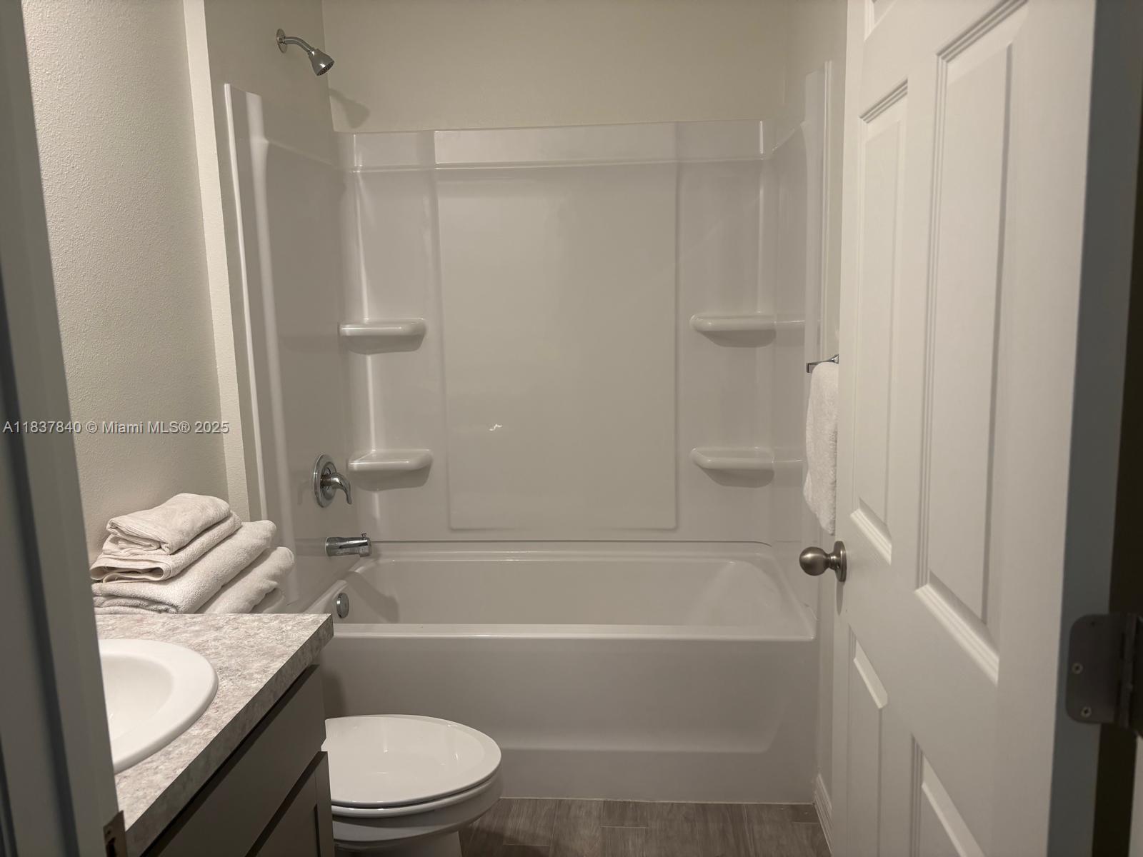 1073 Southwest Eureka Avenue, Unit 1073 Port St. Lucie, FL 34953 - Photo 22 of 25 a bathroom with a granite countertop bathtub shower sink vanity and toilet