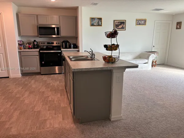 a kitchen with stainless steel appliances granite countertop a sink and a stove