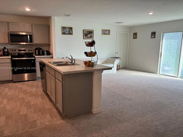 a kitchen with stainless steel appliances granite countertop a stove top oven a sink dishwasher and a microwave oven on the blue kitchen countertops