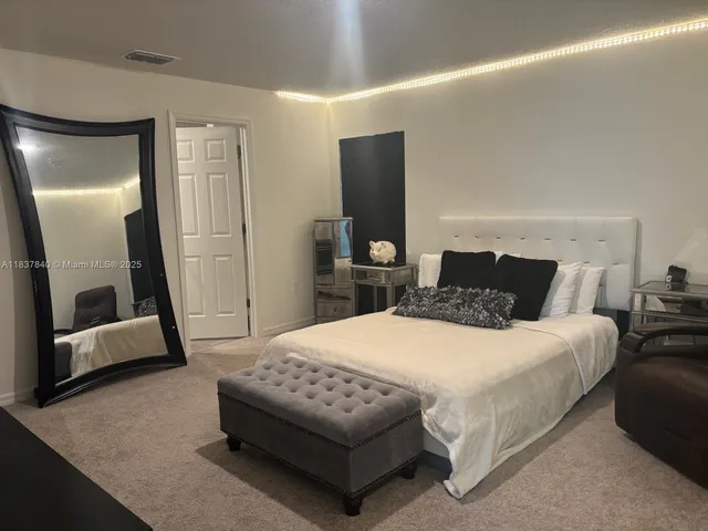 a bedroom with a bed and a large mirror in it