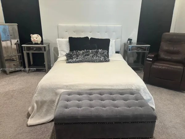 a bed sitting in a bedroom and chair
