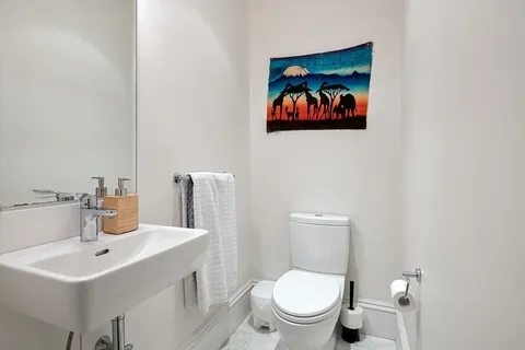 a bathroom with a toilet a sink and mirror
