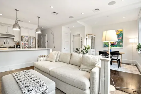 a living room with furniture and kitchen view