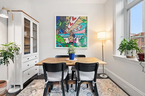a view of a dining room with furniture and a potted plant