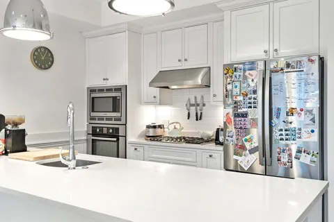 a kitchen with stainless steel appliances a stove a sink and cabinets