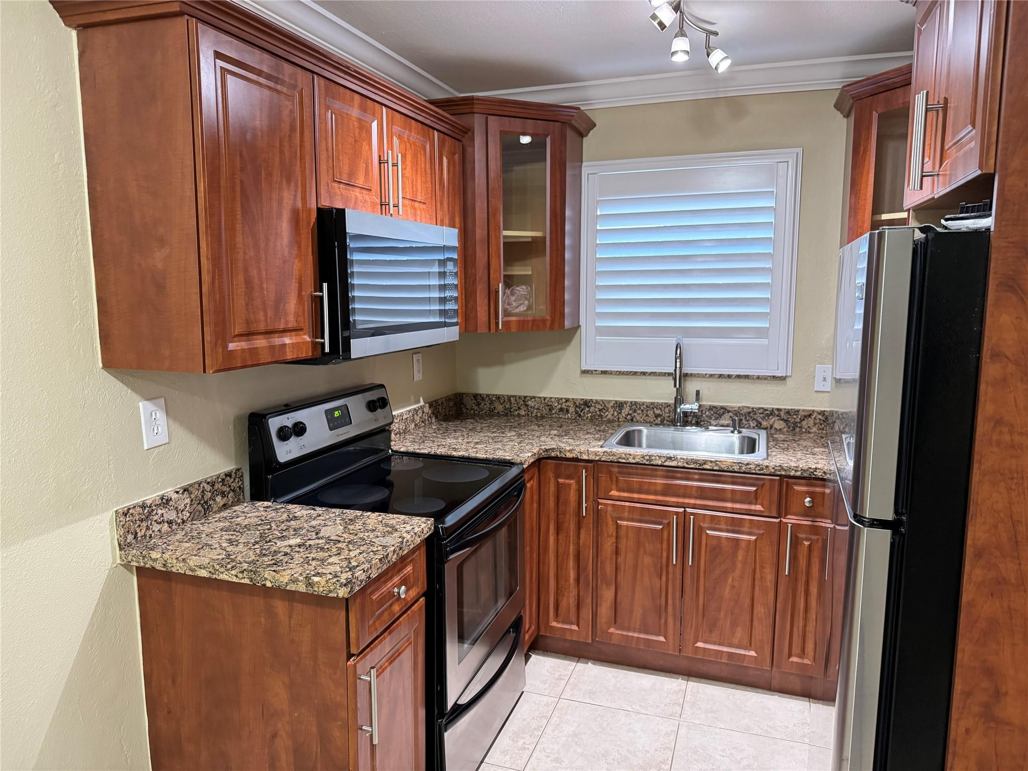 1925 Madison Street, Unit 21 Hollywood, FL 33020 - Photo 2 of 10 a kitchen with granite countertop sink stove and refrigerator